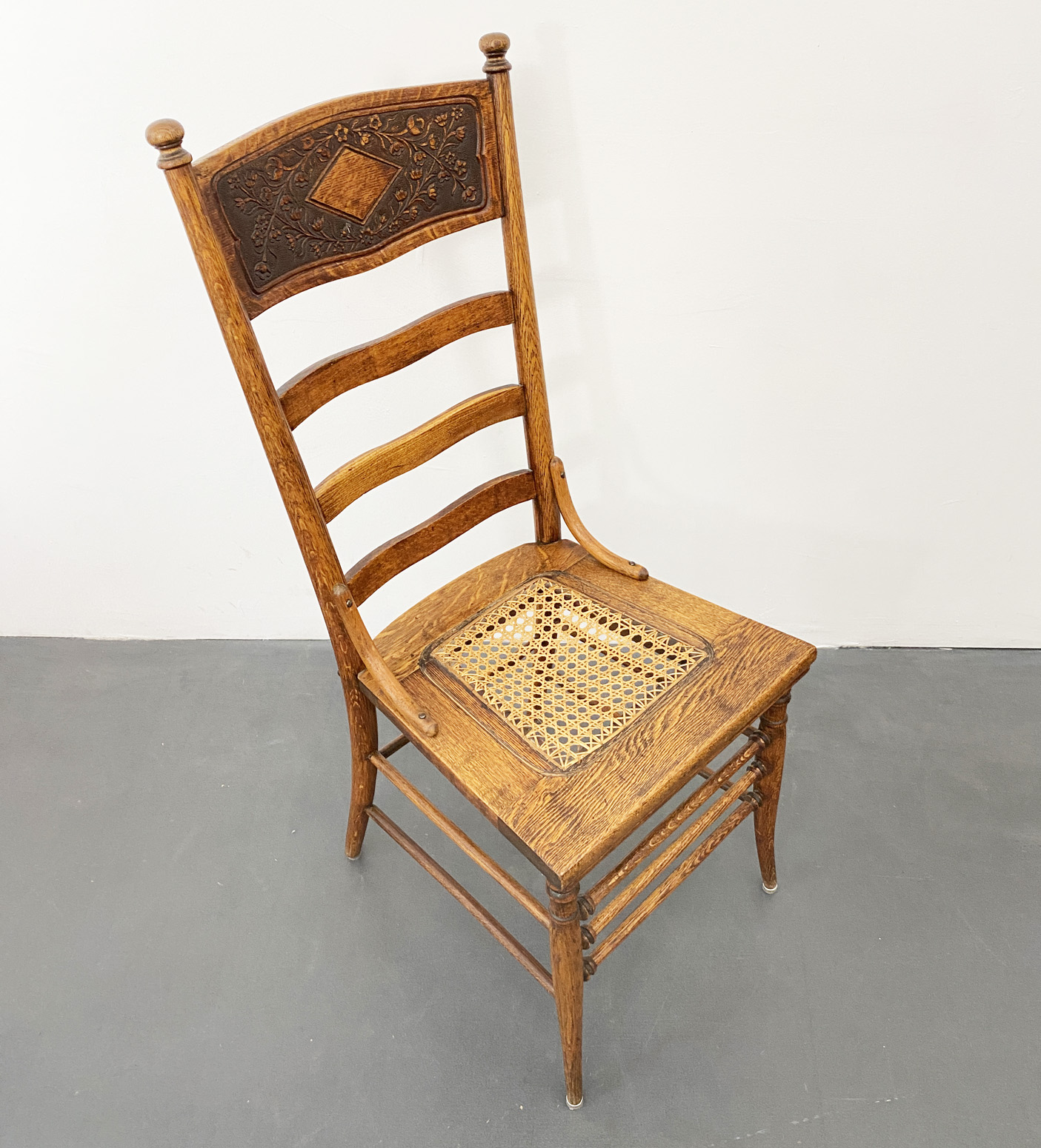 Wooden Chair with high Backrest, Wickerwork and carved floral Decor, around 1880.